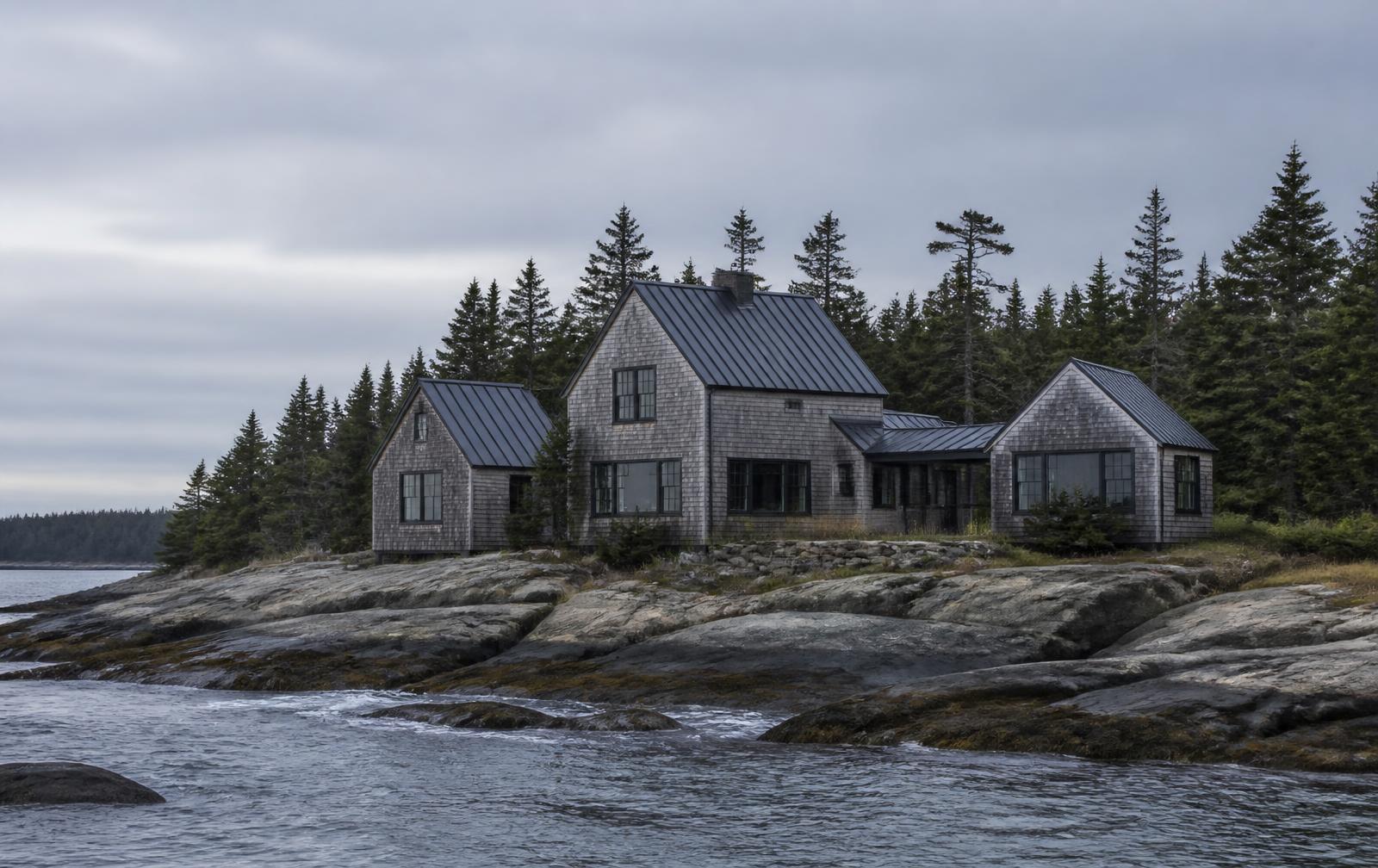 Concept visualization of a coastal Maine residence seen from the water — linked gabled shingle volumes on granite ledge with spruce forest behind