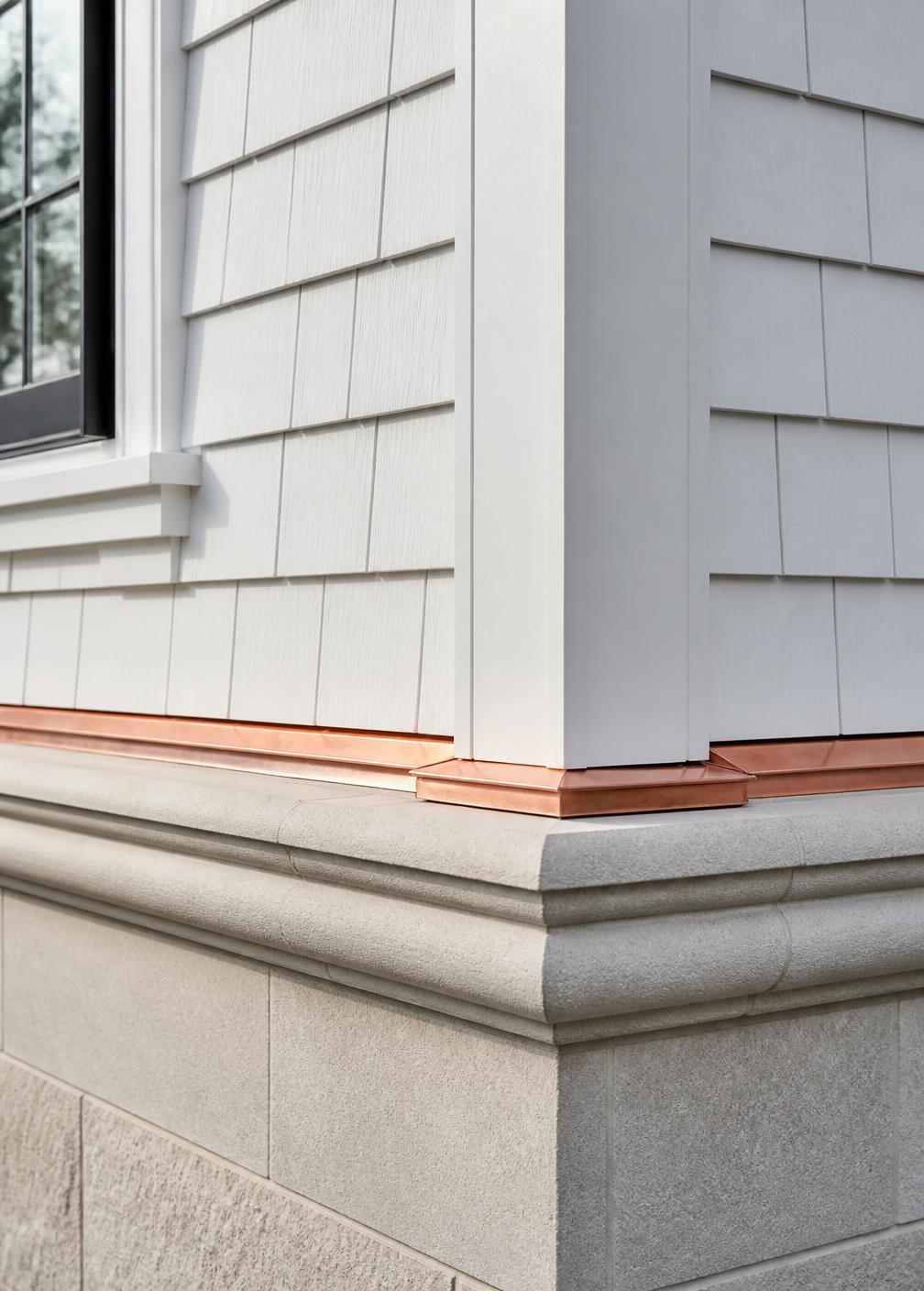 Concept visualization of an exterior carpentry detail where white cedar shingles, corner boards and a limestone water table meet with copper flashing