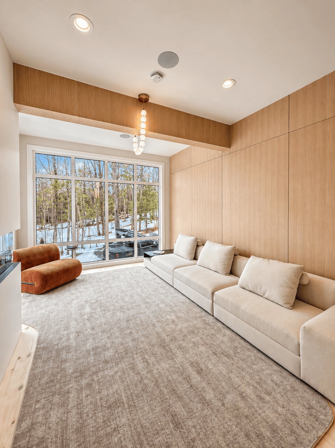 Bedford Residence vaulted living room lined in white oak with a wall of glass to the treeline