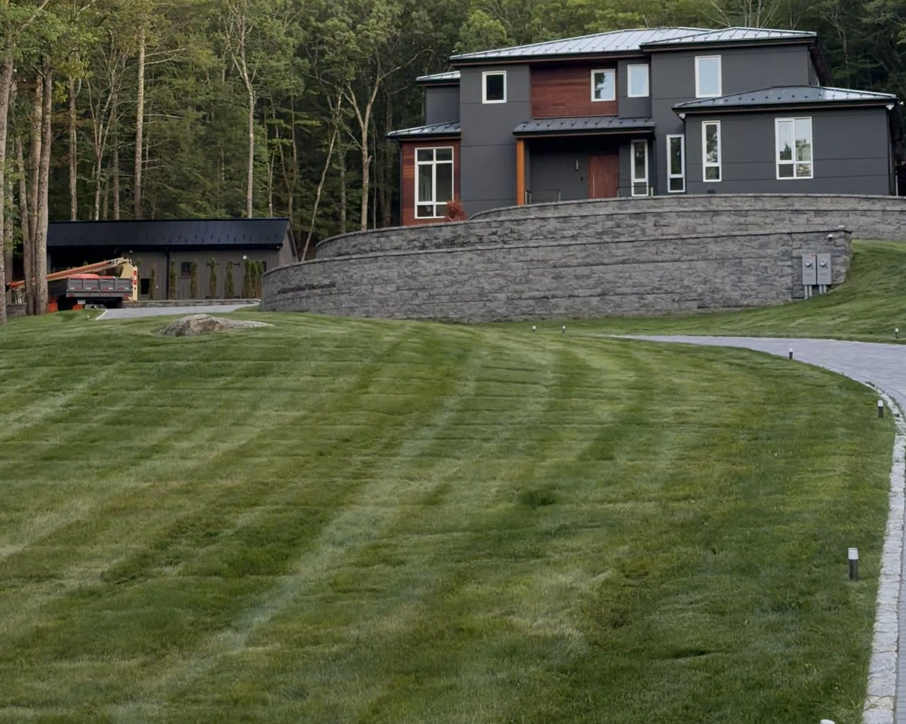 Bedford Residence across the graded lawn with detached barn and courtyard wall