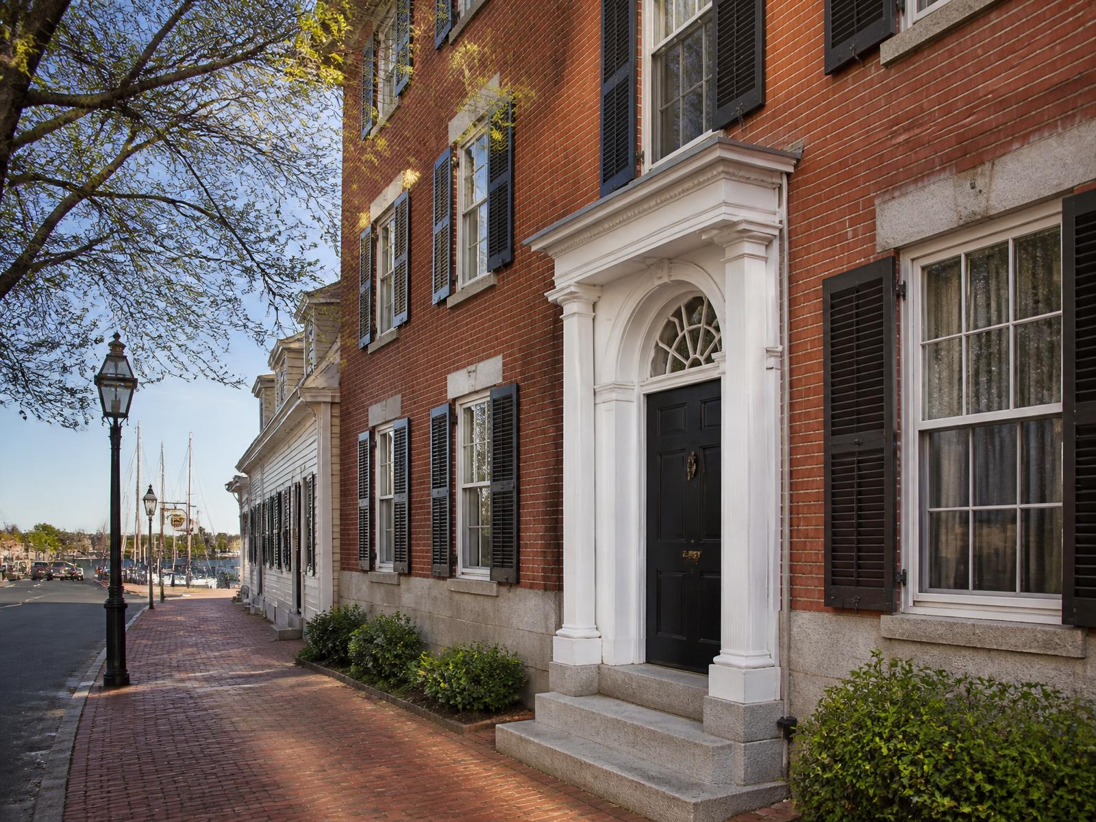 Restored Federal brick townhouse with fanlight entry and granite steps on a Newburyport harbor street