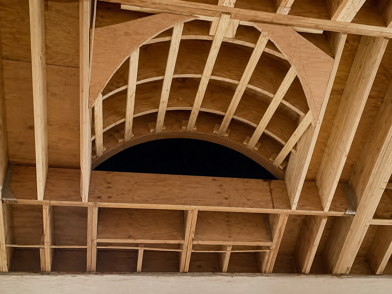 Arched structural ribs aligned by hand before finish work begins