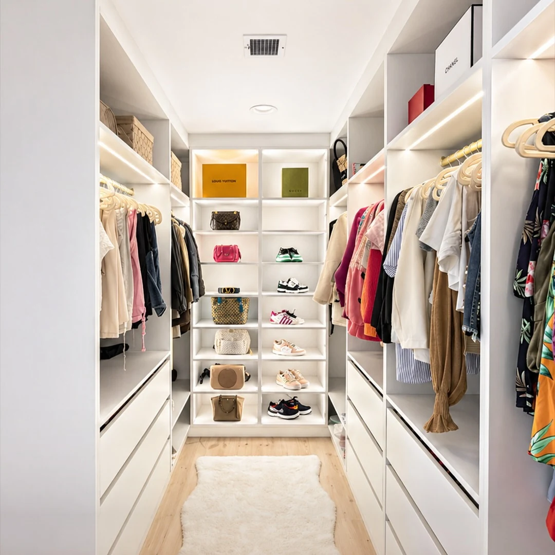 Dressing room at the Bedford Residence with lit open shelving, hanging runs and banks of drawers