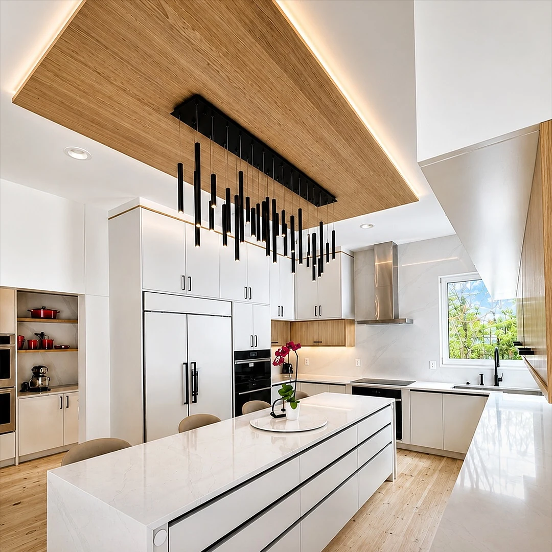 Kitchen at the Bedford Residence with a full-length stone island, slab cabinetry and a backlit white oak ceiling raft carrying a linear pendant array
