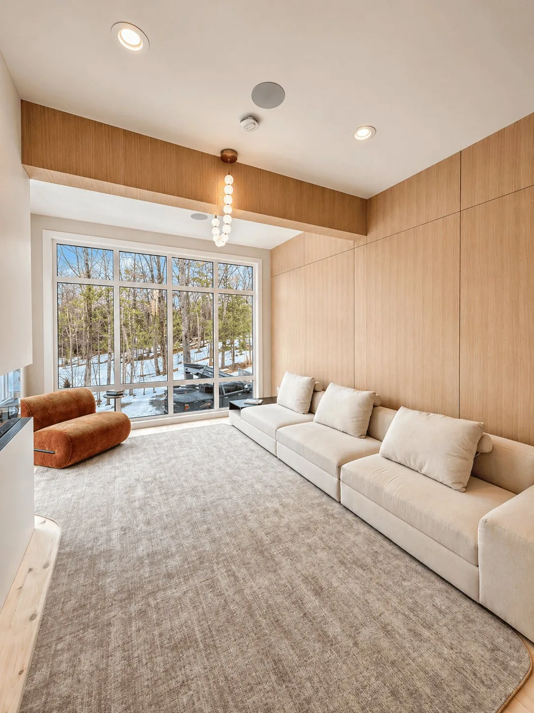 Bedford Residence vaulted living room lined in white oak with a wall of glass to the treeline