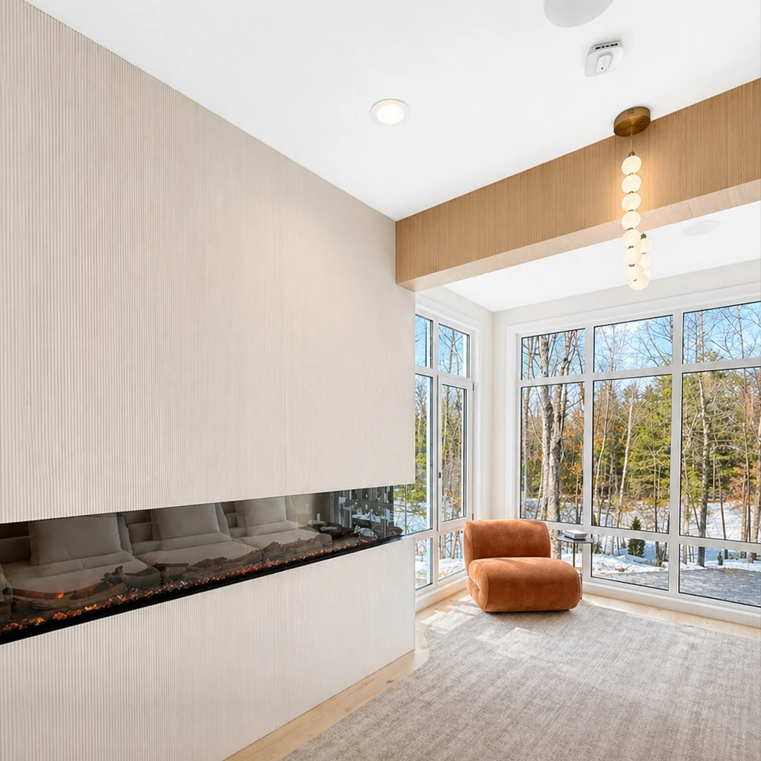 Linear fireplace set into a full-height plaster wall in the lounge at the Bedford Residence