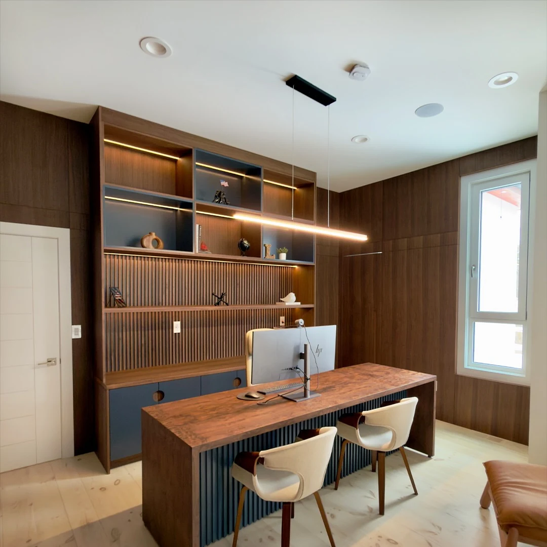 Home office at the Bedford Residence with walnut shelving, fluted panelling, integrated linear lighting and a solid walnut desk