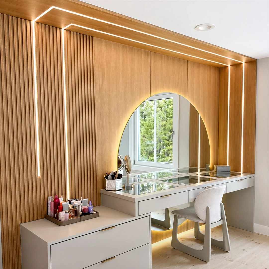 Dressing vanity at the Bedford Residence set in a slatted white oak wall with a backlit arched mirror